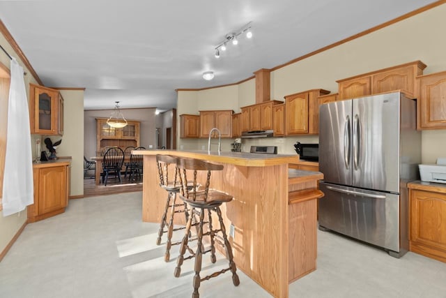 227 Cedar St, Ripon, WI 54971 - kitchen with freestanding refrigerator, light flooring, black microwave, light countertops, and a kitchen bar