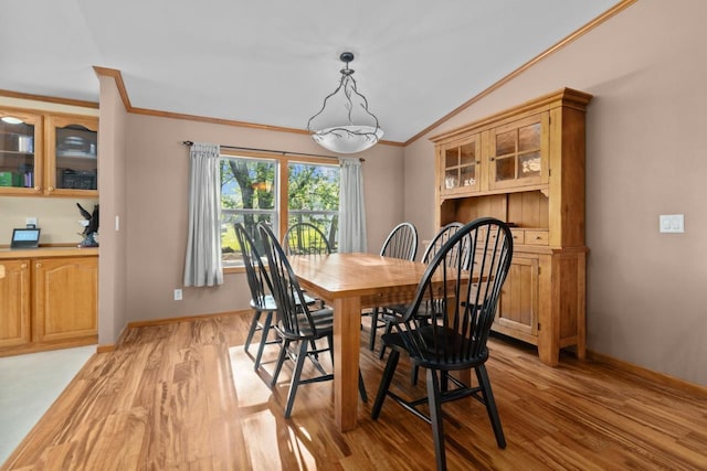 227 Cedar St, Ripon, WI 54971 - dining space with ornamental molding, light wood finished floors, vaulted ceiling, and baseboards