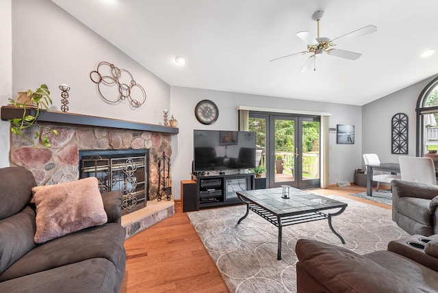 1300 Hidden Fields Dr, West Bend, WI 53095 - living area with lofted ceiling, healthy amount of natural light, ceiling fan, wood finished floors, and a stone fireplace
