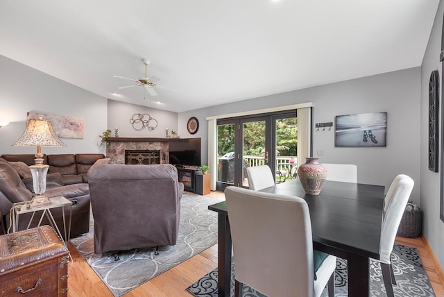 1300 Hidden Fields Dr, West Bend, WI 53095 - living room featuring a ceiling fan, light wood-style floors, vaulted ceiling, and a premium fireplace