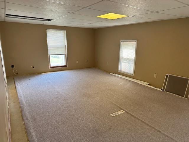420 Jackson St, Waupun, WI 53963 - unfurnished room with a paneled ceiling, plenty of natural light, and light carpet