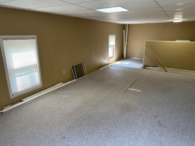 420 Jackson St, Waupun, WI 53963 - spare room featuring carpet, a paneled ceiling, and baseboards