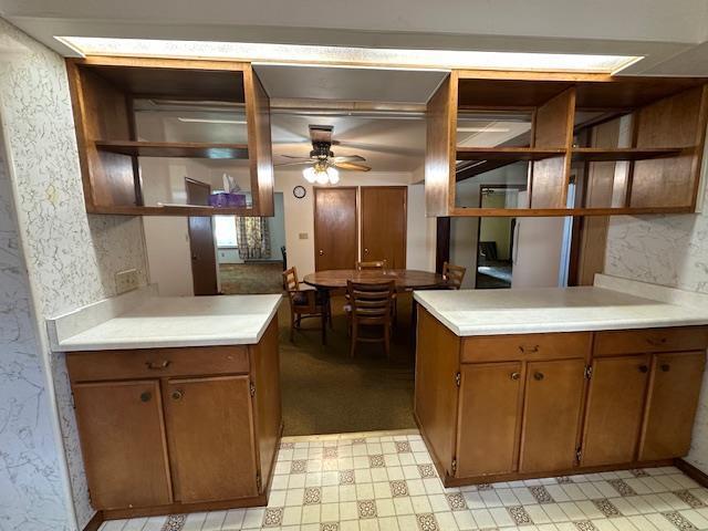 420 Jackson St, Waupun, WI 53963 - kitchen featuring open shelves, ceiling fan, light countertops, brown cabinetry, and light flooring