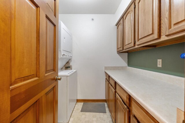 530 N Silverbrook Dr Unit 121, West Bend, WI 53090 - laundry area featuring stacked washer / drying machine, cabinet space, and light flooring