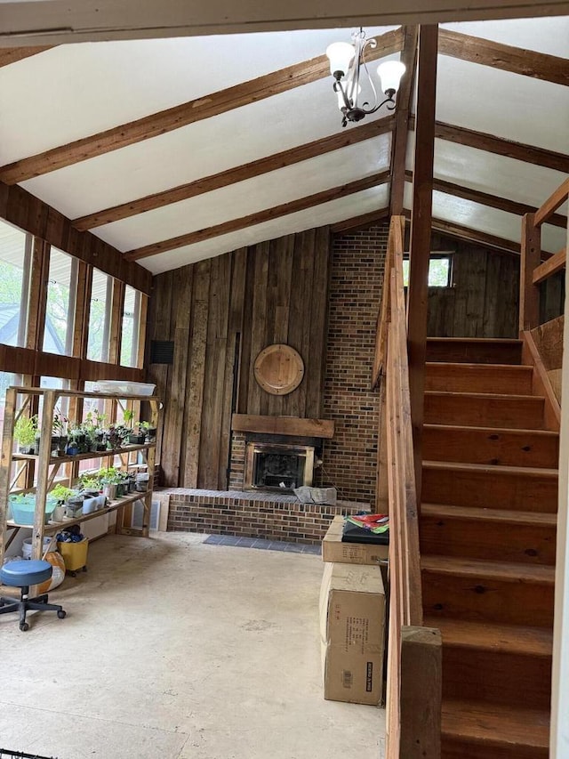 4726 N Green Bay Rd, Racine, WI 53404 - living room featuring stairway, wooden walls, a chandelier, and a brick fireplace