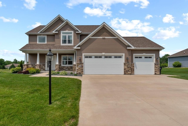 6028 Star Grass Ln, Racine, WI 53406 - craftsman-style house with concrete driveway, a garage, a front lawn, and stone siding