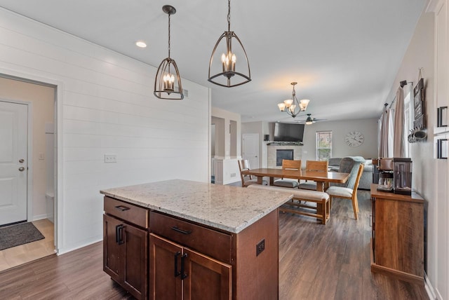 6028 Star Grass Ln, Racine, WI 53406 - kitchen featuring a chandelier, open floor plan, dark wood-style floors, hanging light fixtures, and light stone counters