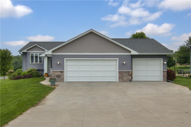 964 S Kelly Rd, Ellsworth, WI 54011 - view of front of property with a garage, concrete driveway, stone siding, and a front yard