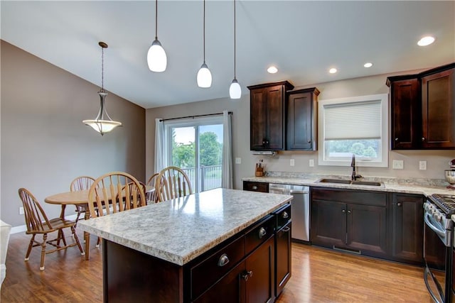 964 S Kelly Rd, Ellsworth, WI 54011 - kitchen with stainless steel appliances, light wood-style flooring, dark brown cabinetry, a center island, and pendant lighting