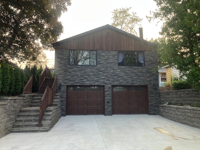 W341N4803 E Lindy Ln, Nashotah, WI 53058 - view of front facade featuring stairs, an attached garage, concrete driveway, and stone siding
