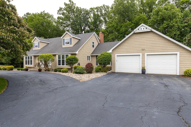 11 Meadowbrook Ct, Appleton, WI 54914 - cape cod home featuring asphalt driveway, a chimney, and view of scattered trees