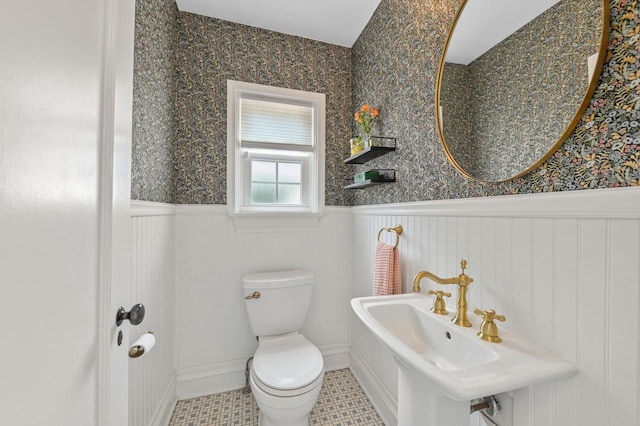 6223 W Wisconsin Ave, Wauwatosa, WI 53213 - half bathroom featuring a wainscoted wall, tile patterned flooring, and a decorative wall