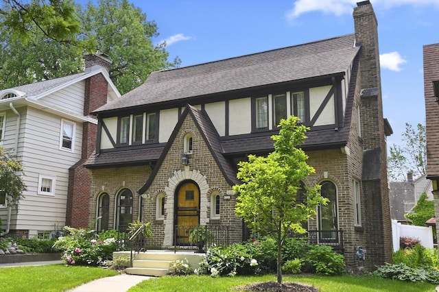 6223 W Wisconsin Ave, Wauwatosa, WI 53213 - tudor house with a shingled roof, stucco siding, and brick siding