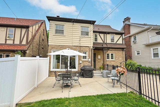 6223 W Wisconsin Ave, Wauwatosa, WI 53213 - rear view of property with brick siding, a patio area, and a fenced backyard