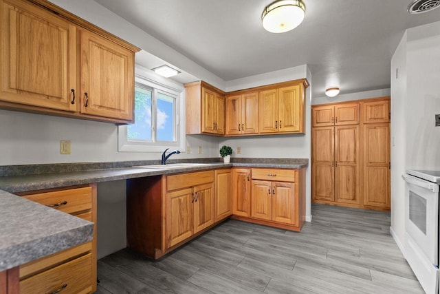 N1128 County Rd W, Fremont, WI 54940 - kitchen featuring range, dark countertops, wood finished floors, and brown cabinetry