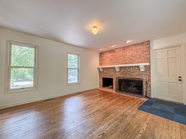 417 Anglesey Rd, Wales, WI 53183 - unfurnished living room with wood-type flooring and a brick fireplace