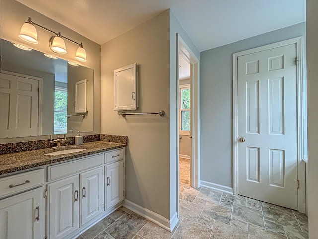 417 Anglesey Rd, Wales, WI 53183 - bathroom with vanity, plenty of natural light, and stone finish floors