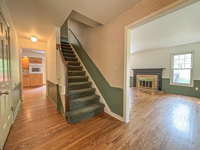 417 Anglesey Rd, Wales, WI 53183 - stairway with wood finished floors and a brick fireplace