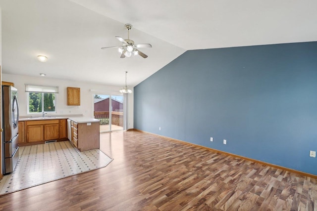 609-611 Eagle Crest Ct, Prairie Du Sac, WI 53578 - kitchen with freestanding refrigerator, light wood-type flooring, ceiling fan, vaulted ceiling, and a chandelier