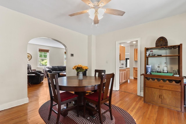 1133 Racine St, Delavan, WI 53115 - dining space featuring arched walkways, light wood-type flooring, and ceiling fan