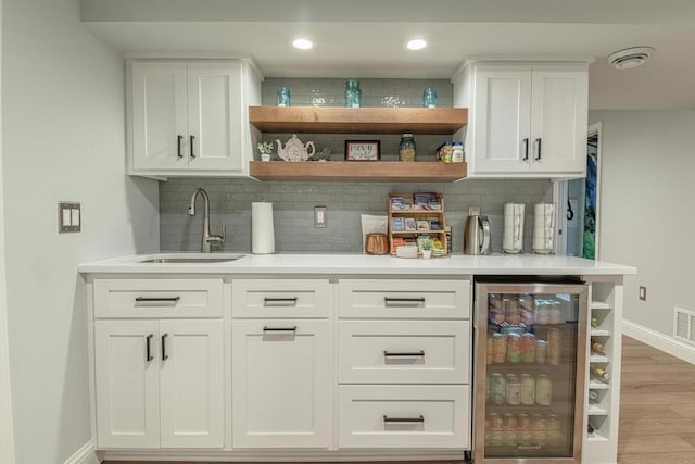 3472 Hickory Hill Rd, Verona, WI 53593 - indoor bar featuring beverage cooler, backsplash, light wood finished floors, and recessed lighting