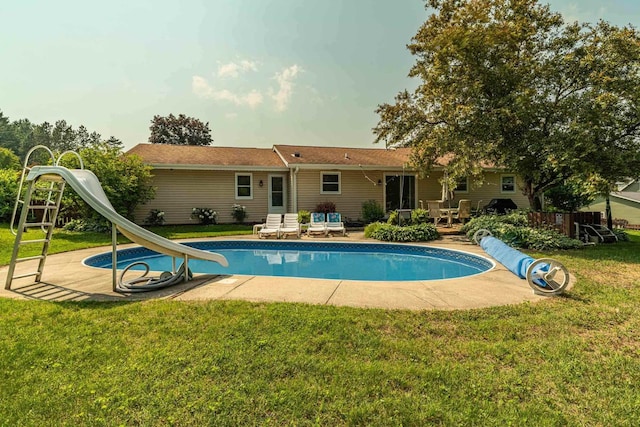3472 Hickory Hill Rd, Verona, WI 53593 - view of swimming pool with a water slide, a covered pool, a yard, and a deck
