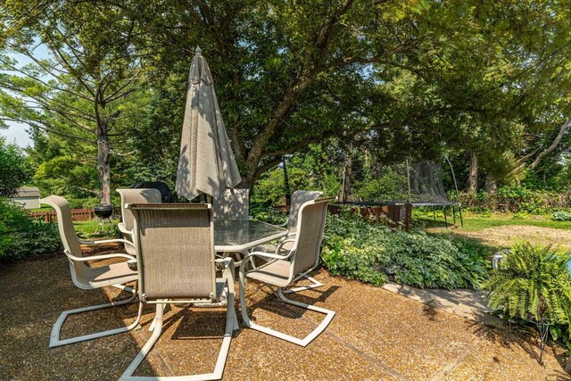 3472 Hickory Hill Rd, Verona, WI 53593 - view of patio with a trampoline, outdoor dining area, and view of wooded area