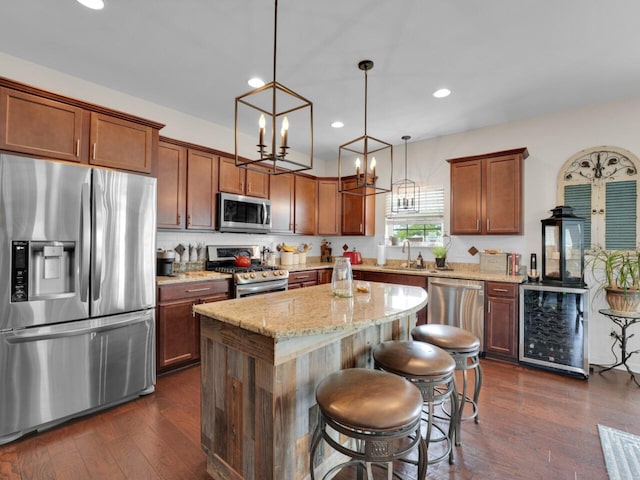 3605 Emmertsen Rd, Racine, WI 53406 - kitchen featuring appliances with stainless steel finishes, wine cooler, a kitchen island, light stone counters, and recessed lighting