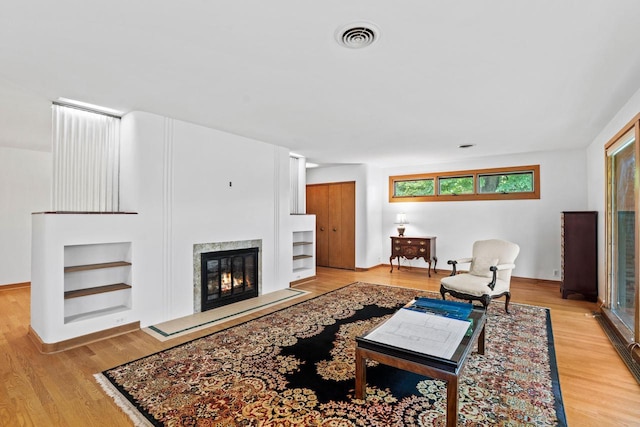 3358 Taylor Ave, Elmwood Park, WI 53405 - living room featuring built in features, a fireplace, and wood finished floors