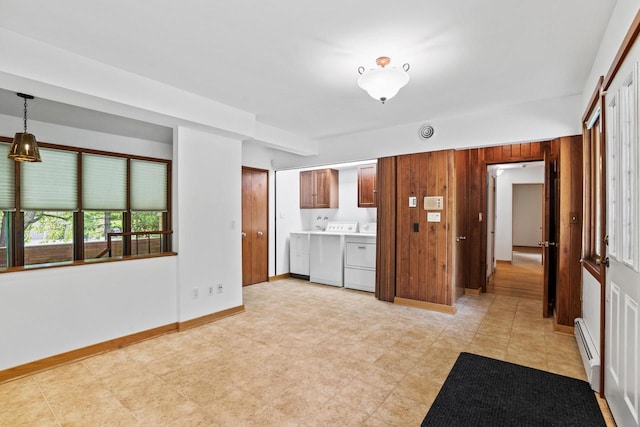 3358 Taylor Ave, Elmwood Park, WI 53405 - kitchen featuring a baseboard radiator, washer and dryer, light countertops, wooden walls, and pendant lighting