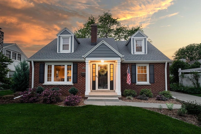 2461 N 94th St, Wauwatosa, WI 53226 - new england style home with brick siding, a chimney, a lawn, and a shingled roof