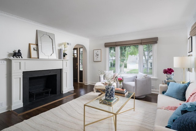 2461 N 94th St, Wauwatosa, WI 53226 - living room featuring arched walkways, dark wood finished floors, ornamental molding, and a fireplace