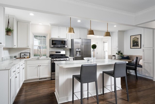 2461 N 94th St, Wauwatosa, WI 53226 - kitchen with appliances with stainless steel finishes, a center island, white cabinets, recessed lighting, and ornamental molding