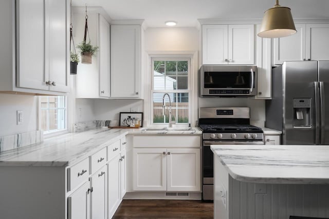 2461 N 94th St, Wauwatosa, WI 53226 - kitchen featuring appliances with stainless steel finishes, white cabinetry, light stone counters, and decorative light fixtures