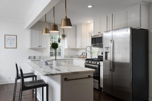 2461 N 94th St, Wauwatosa, WI 53226 - kitchen with appliances with stainless steel finishes, a kitchen island, dark wood finished floors, recessed lighting, and light stone countertops