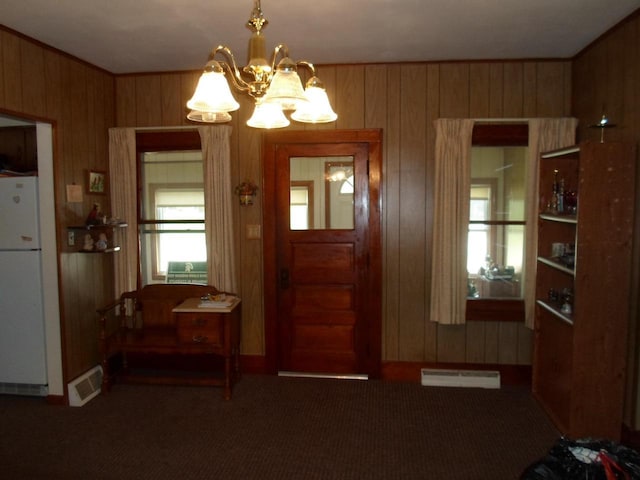 212 E Bowen St, Brandon, WI 53919 - foyer with wood walls, a chandelier, and carpet flooring