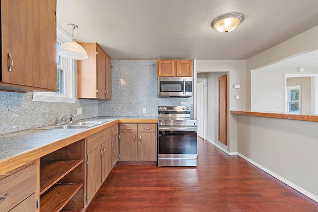 2717 13th St, Two Rivers, WI 54241 - kitchen with stainless steel appliances, backsplash, light countertops, dark wood-type flooring, and hanging light fixtures