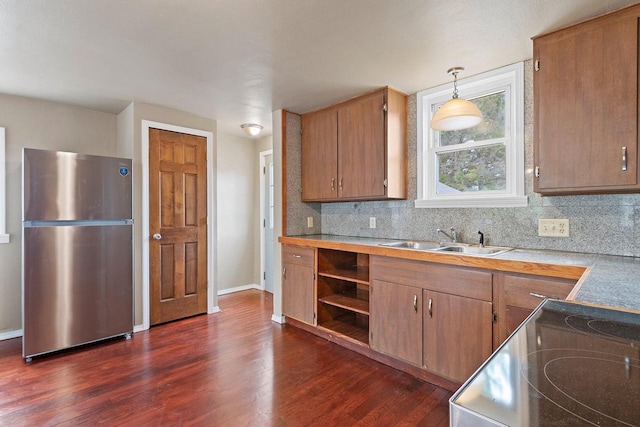 2717 13th St, Two Rivers, WI 54241 - kitchen with freestanding refrigerator, dark wood-style flooring, tasteful backsplash, decorative light fixtures, and light countertops