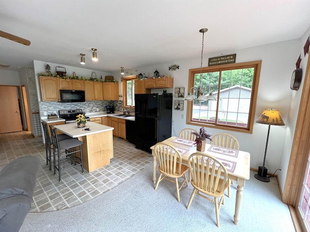 2783 High Peak Rd, Rhinelander, WI 54501 - kitchen with black appliances, light countertops, tasteful backsplash, a center island, and a kitchen bar