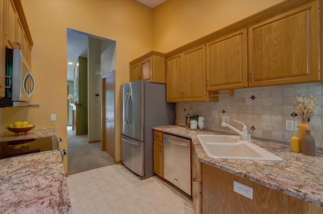 3 Deer Point Trl, Madison, WI 53719 - kitchen with stainless steel appliances, decorative backsplash, light stone countertops, light colored carpet, and brown cabinets
