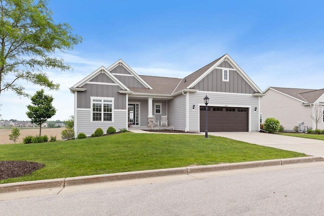 1386 Overlook Cir, Hartland, WI 53029 - craftsman-style home featuring board and batten siding, a front lawn, an attached garage, concrete driveway, and a porch