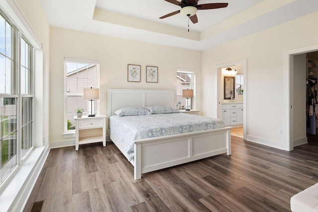1386 Overlook Cir, Hartland, WI 53029 - bedroom featuring dark wood-style floors, a raised ceiling, ensuite bathroom, and a walk in closet