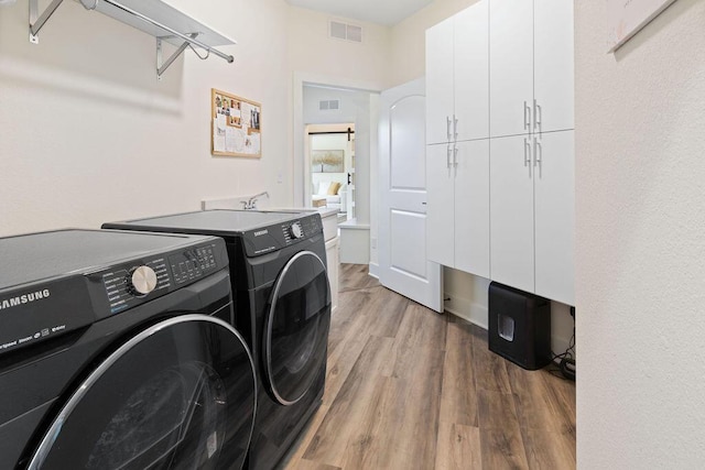 1386 Overlook Cir, Hartland, WI 53029 - laundry room with cabinet space, separate washer and dryer, and wood finished floors