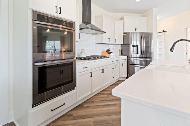 1386 Overlook Cir, Hartland, WI 53029 - kitchen featuring appliances with stainless steel finishes, wall chimney exhaust hood, backsplash, and white cabinets