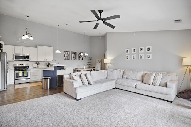 3223 55th Ct Unit 65, Kenosha, WI 53144 - living area with a ceiling fan, carpet, a chandelier, high vaulted ceiling, and wood finished floors
