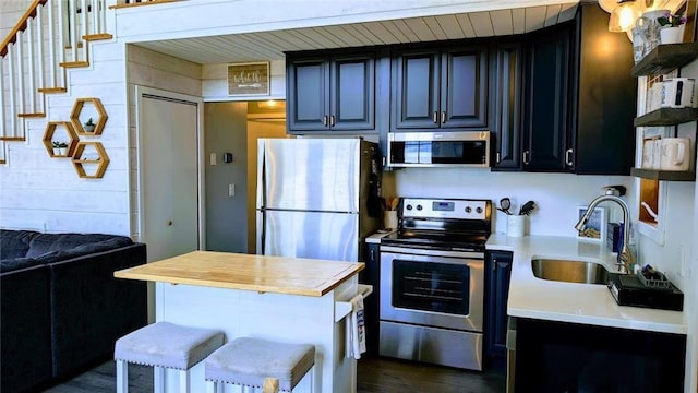 W6741 Lakewood Blvd, Ladysmith, WI 54848 - kitchen featuring stainless steel appliances, dark wood finished floors, open shelves, a center island, and wooden counters