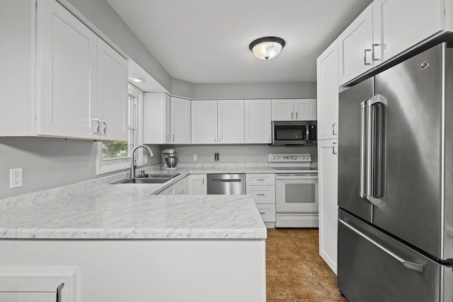 931 W Lindbergh St, Appleton, WI 54914 - kitchen with appliances with stainless steel finishes, white cabinetry, a peninsula, and dark tile patterned flooring