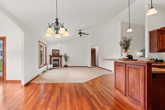 52 Penbrook Cir Unit 47, Appleton, WI 54911 - unfurnished living room with light wood-style flooring, arched walkways, a fireplace with raised hearth, a chandelier, and a ceiling fan