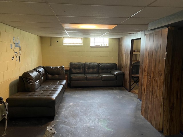 3668 S 79th St, Milwaukee, WI 53220 - living area featuring unfinished concrete floors, concrete block wall, and a paneled ceiling