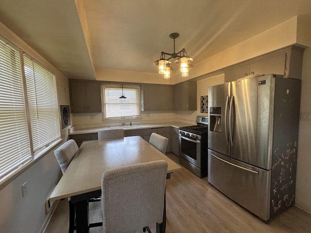 3668 S 79th St, Milwaukee, WI 53220 - kitchen with appliances with stainless steel finishes, light wood-style floors, light countertops, hanging light fixtures, and a center island